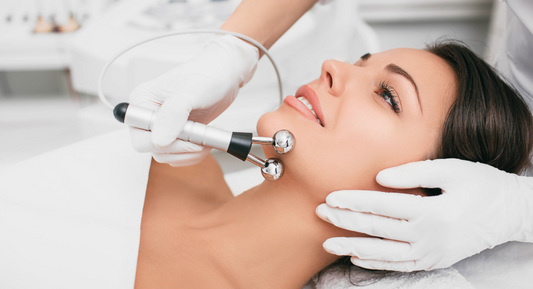Woman enjoys professional microcurrent facial by two hand in white gloves
