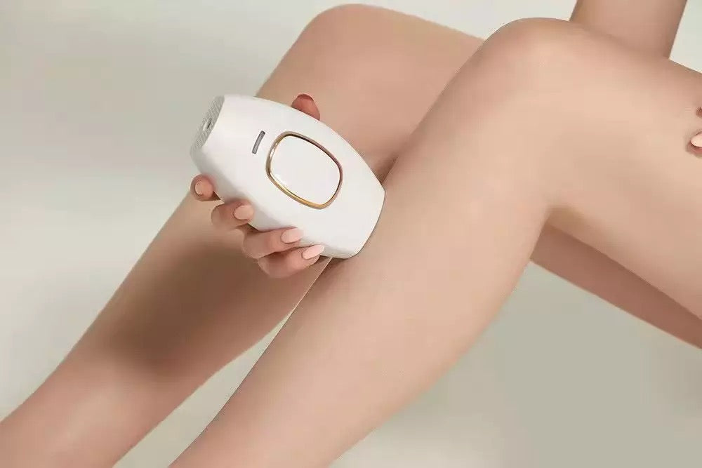Cream white IPL handset is used on woman’s legs